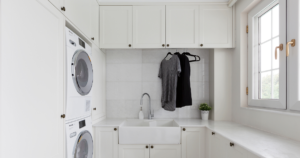 An image of a custom laundry space designed by Creative by Design with two t-shirts hanging on hangers.
